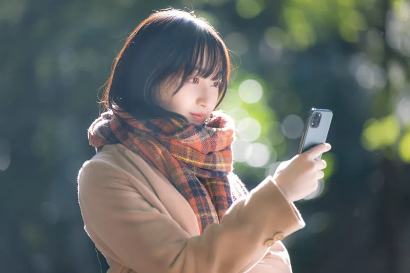 【ケース6】商店街 1 スマートフォンを操作する女性